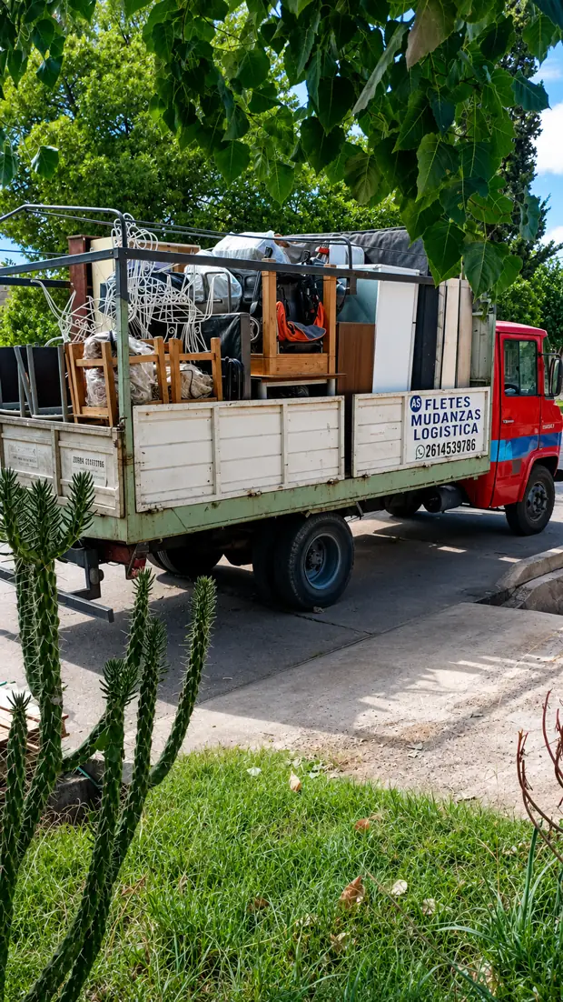 Camión de mudanzas cargado con muebles, sillas y electrodomésticos.